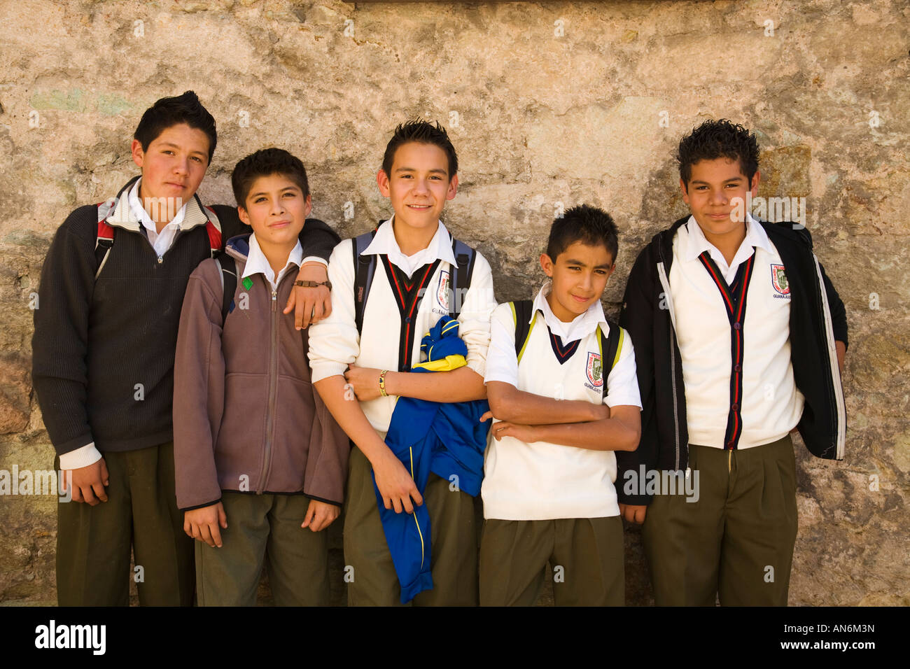 MEXICO Guanajuato Five Mexican boys in school uniforms pose in front of stone wall friends together Stock Photo