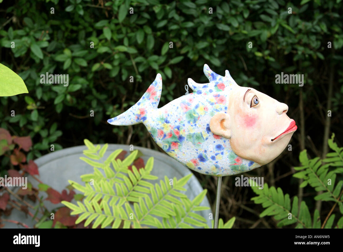 artistic painted ceramic fish humorous ornament  in a private garden Stock Photo