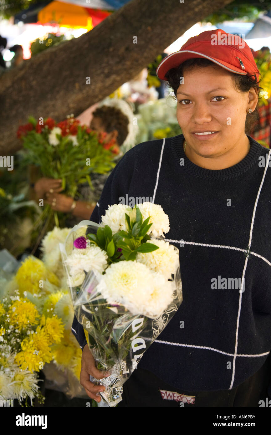 MEXICO Guanajuato Woman holding bouquet of flowers street vendor white