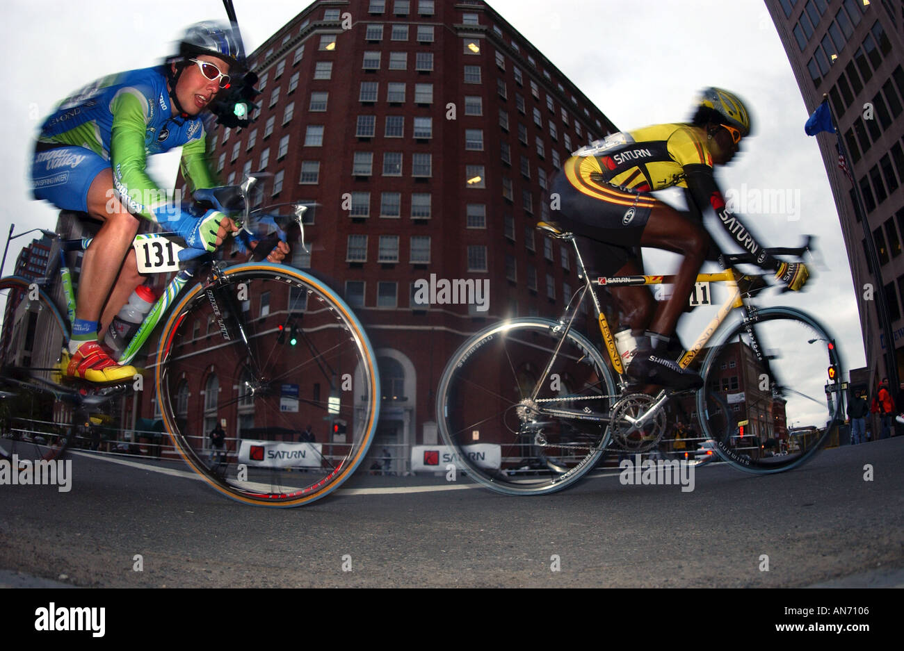 Bike racers race through a city street at dusk Stock Photo - Alamy