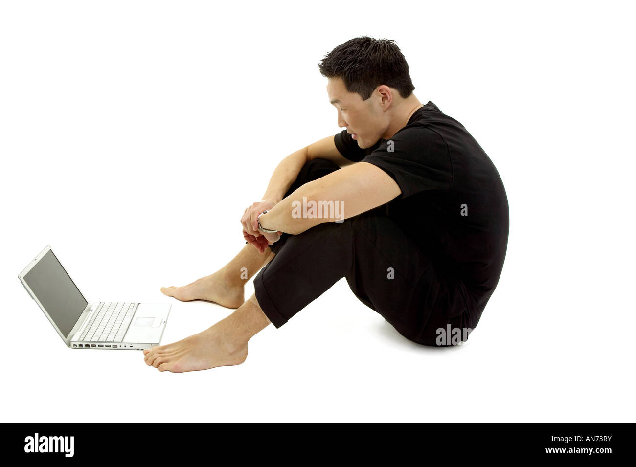 Man Sitting on the Floor with a Laptop Computer Stock Photo - Alamy