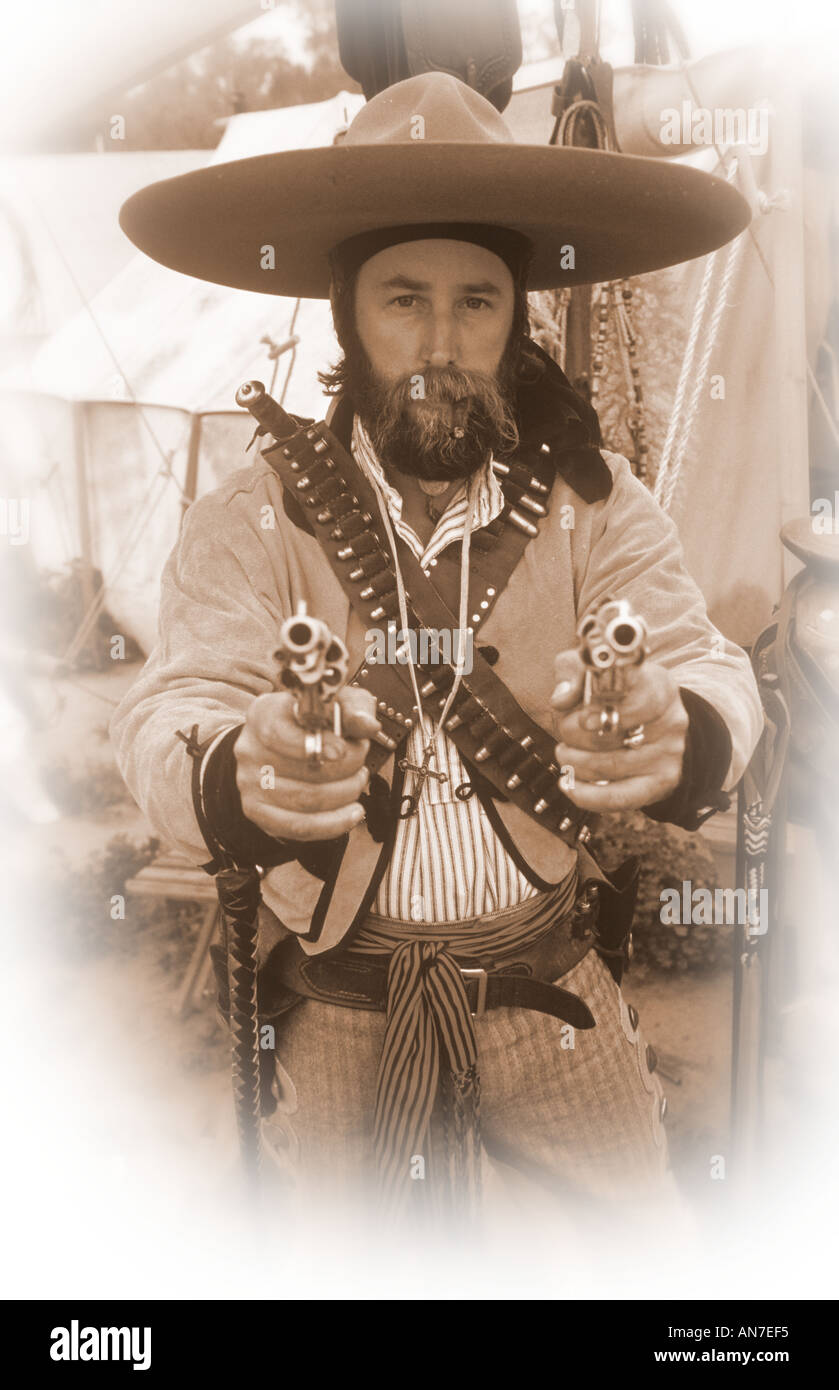Reenactor dressed as a bandito of the Old West pointing his six guns at  camera USA Stock Photo - Alamy