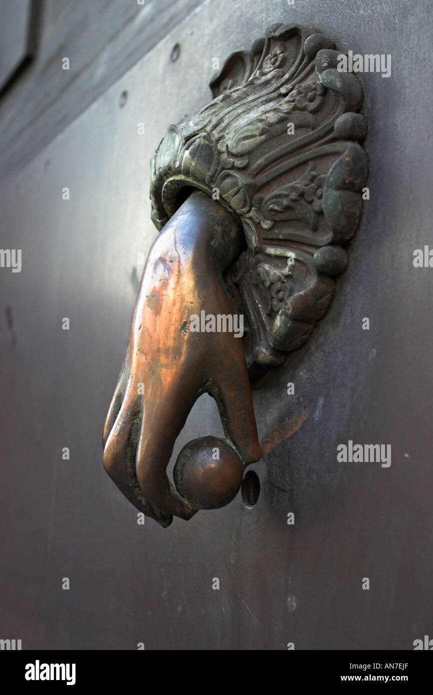 Door Knocker A highly sculpted brass hand holding a ball makes an excellent door knocker Catania Sicily Italy Stock Photo