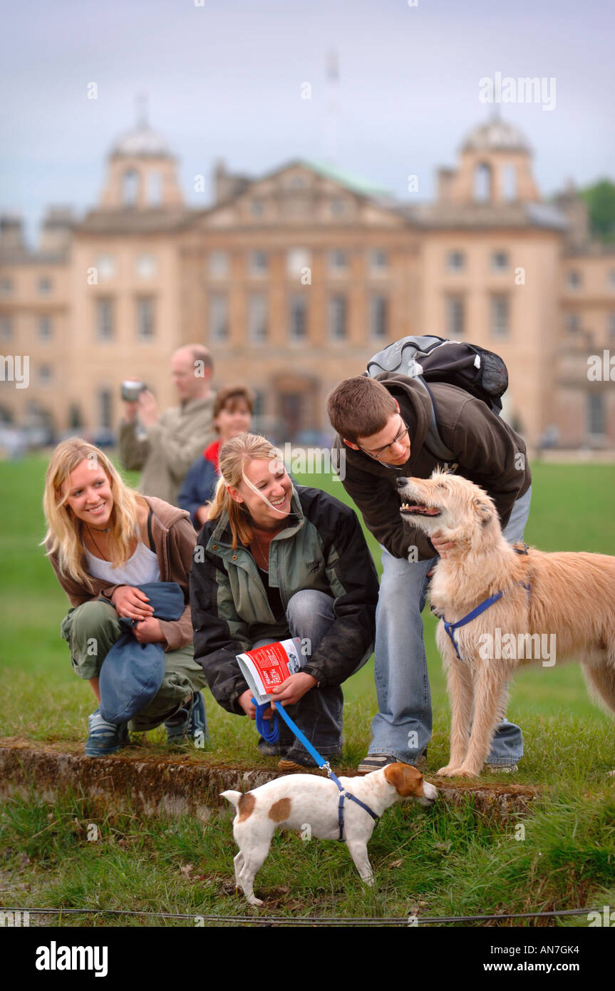 TWO TEENAGE GIRLS AND A BOY PLAYING WITH THEIR DOGS NEAR THE POND AT BADMINTON HORSE TRIALS 2006 UK Stock Photo