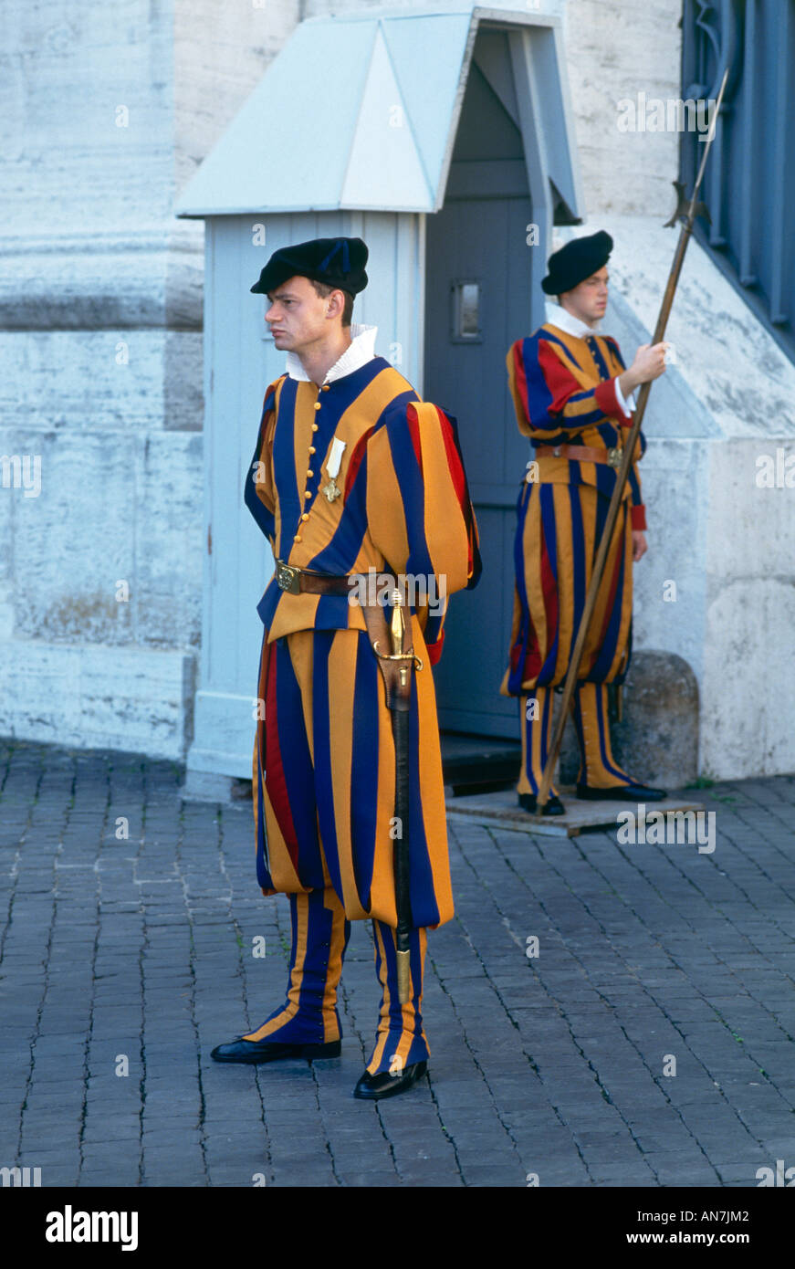 Two members of the Pope s Swiss Guard on duty in the Vatican City wearing  the uniform which was designed by Michelangelo in the medieval colours of  the Medici Popes and which