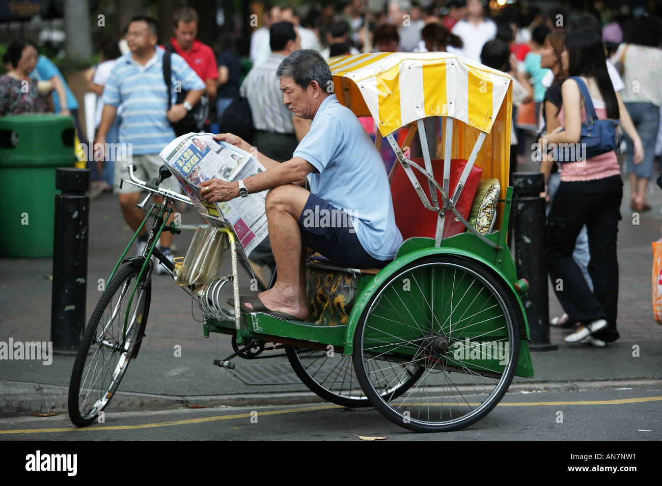 SGP, Singapore Trishaw driver, Newspaper reading Stock Photo Alamy