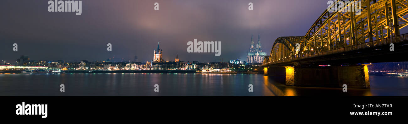 panoramic view of Cologne at night between Deutzer Bridge and Hohenzollern Bridge, with cathedral, St Aposteln church Stock Photo