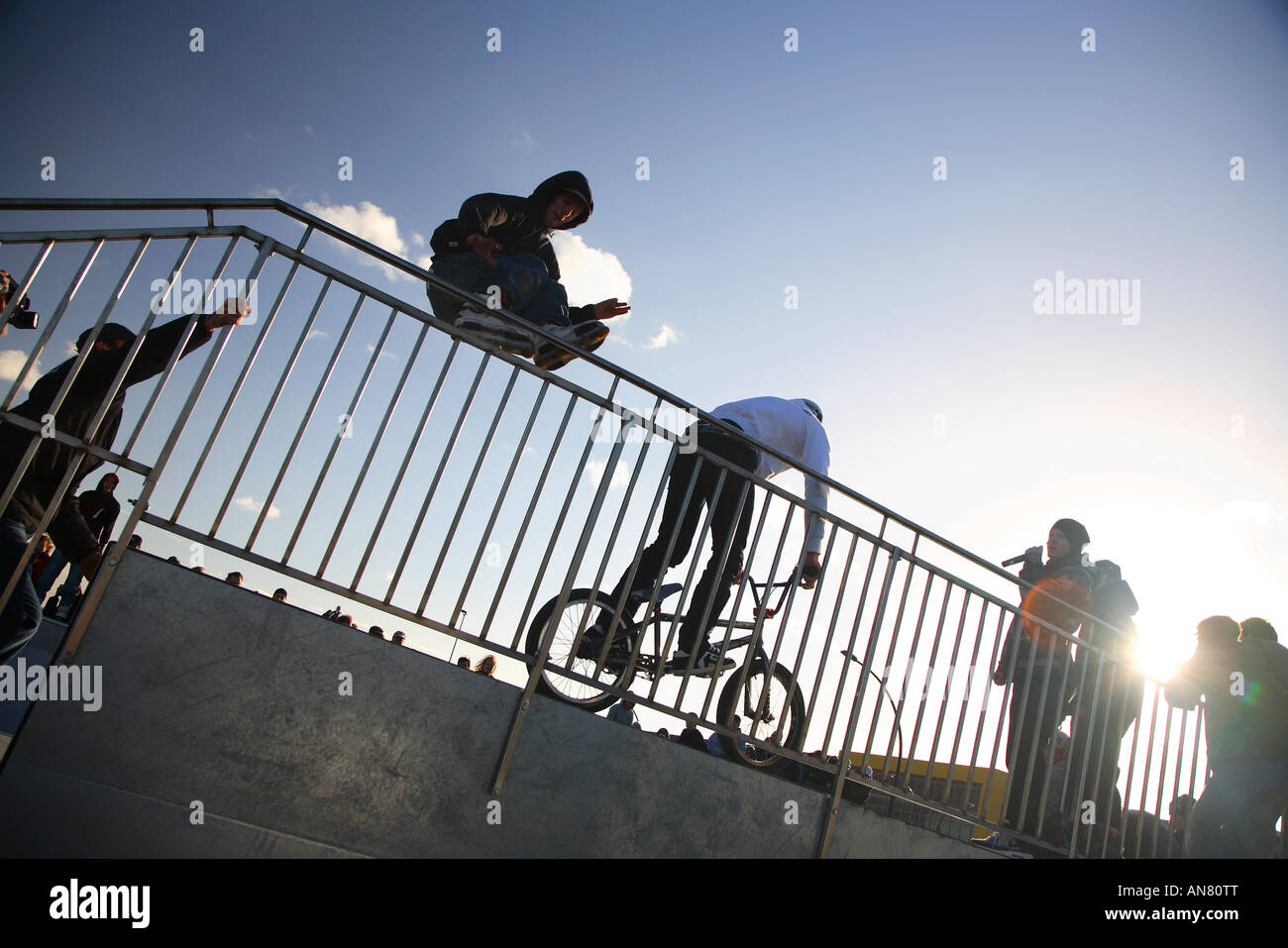 inline skater with skates and bmx cross bike in half pipe at skatepark
