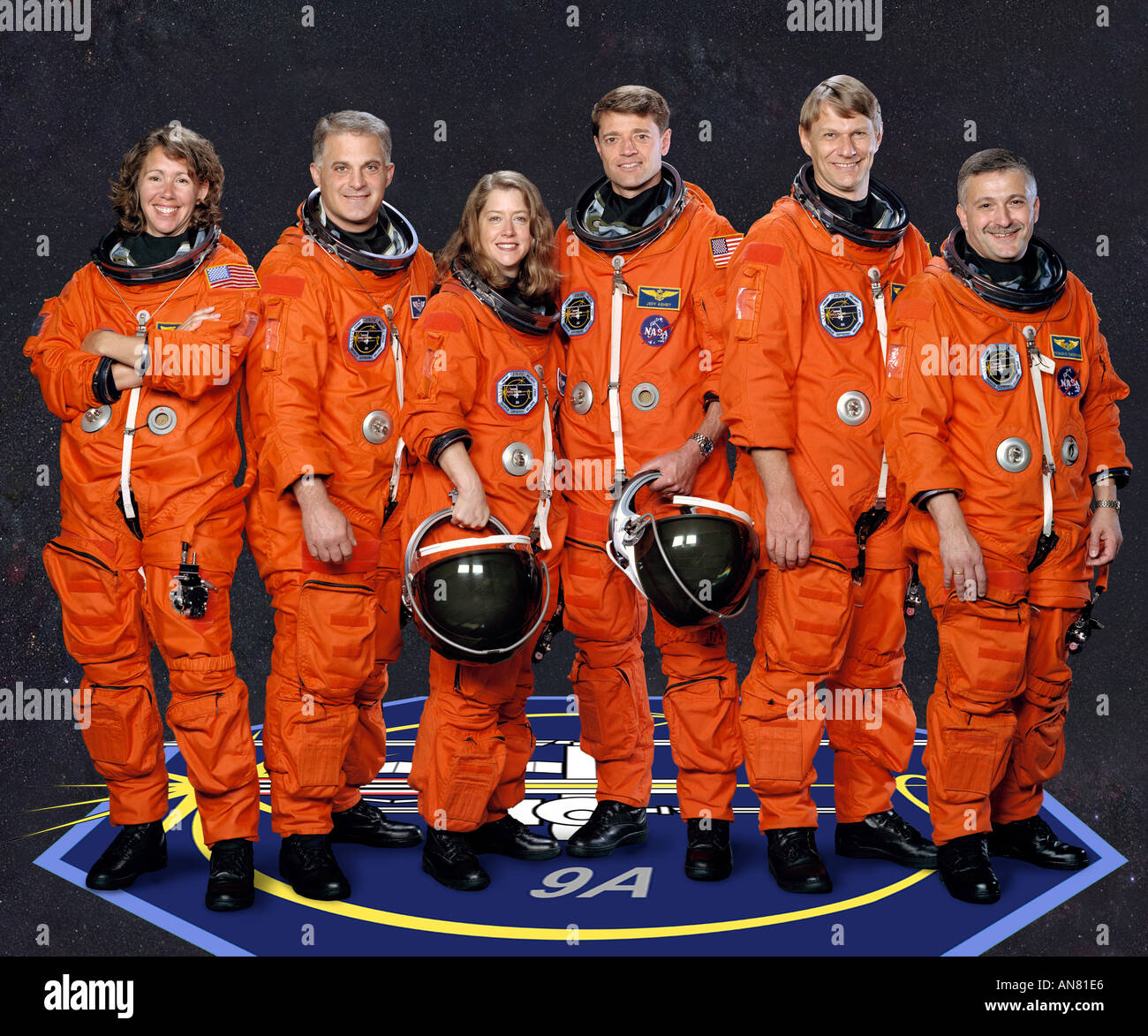 five astronauts and cosmonaut pose for the STS 112 crew portrait in orange space suits Stock Photo