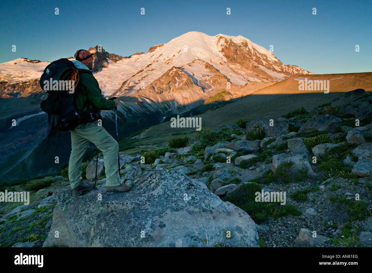 Backpacker and Mt Rainier at sunrise Stock Photo - Alamy
