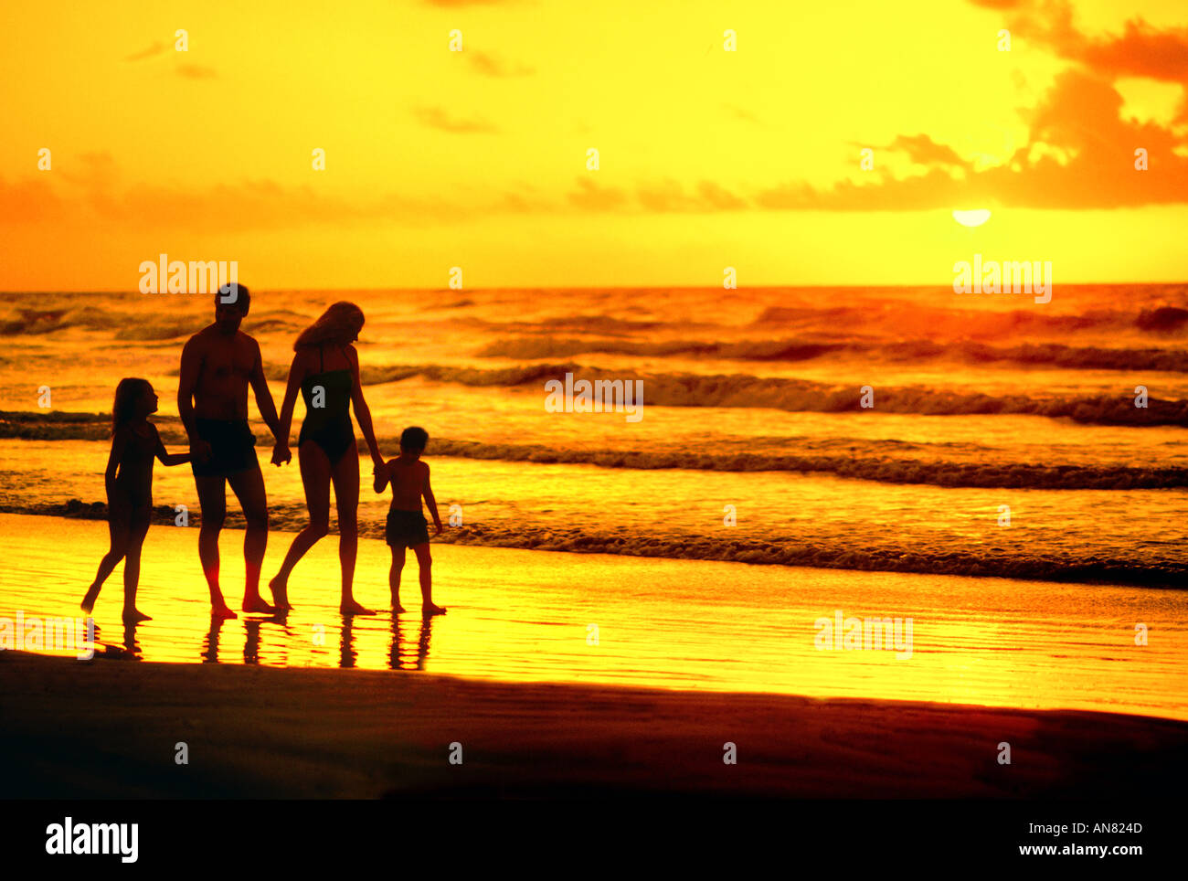 Family of four walking on beach hi-res stock photography and images - Alamy