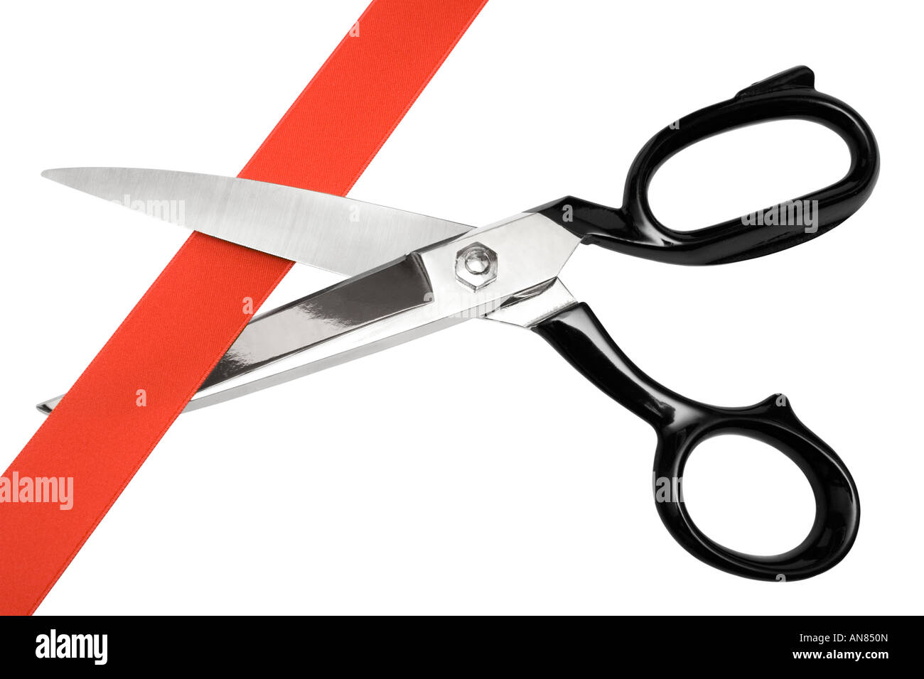 Pair of scissors cutting red ribbon. Isolated on a white background. Stock Photo