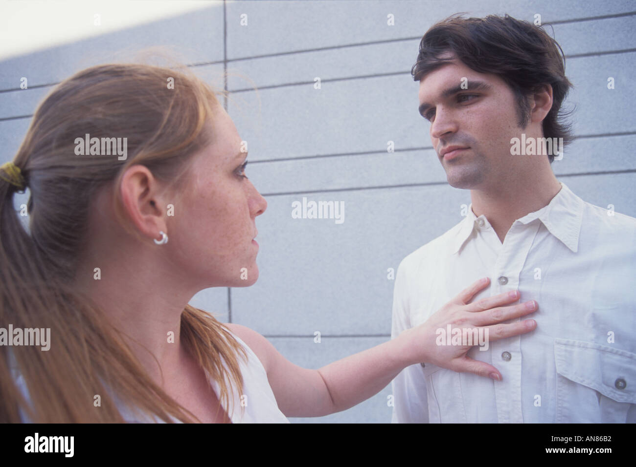 22 year old Caucasian female extending arm into 22 year old Caucasian male Stock Photo