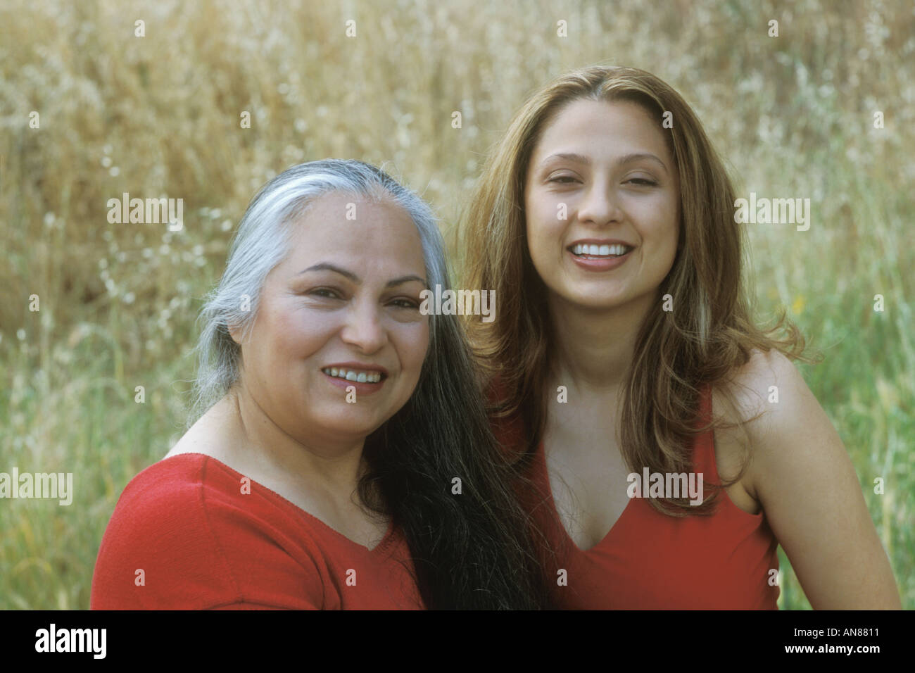 Portrait of 54 year old Hispanic female and 22 year old daughter in golden field Stock Photo
