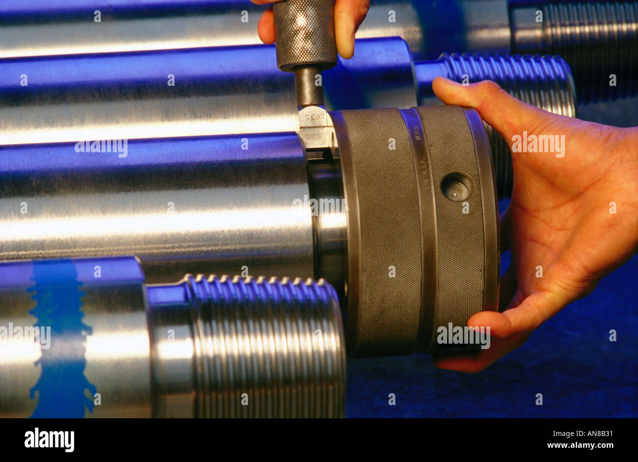 Worker using calibration device to check the width of oil drilling pipe