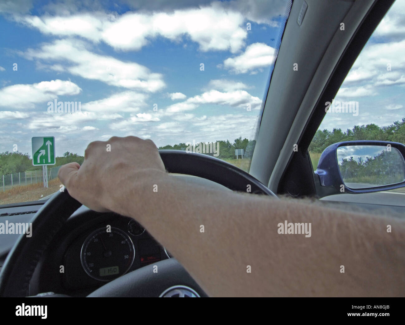 Interior view from a car, steering wheel and drivers arms Stock Photo