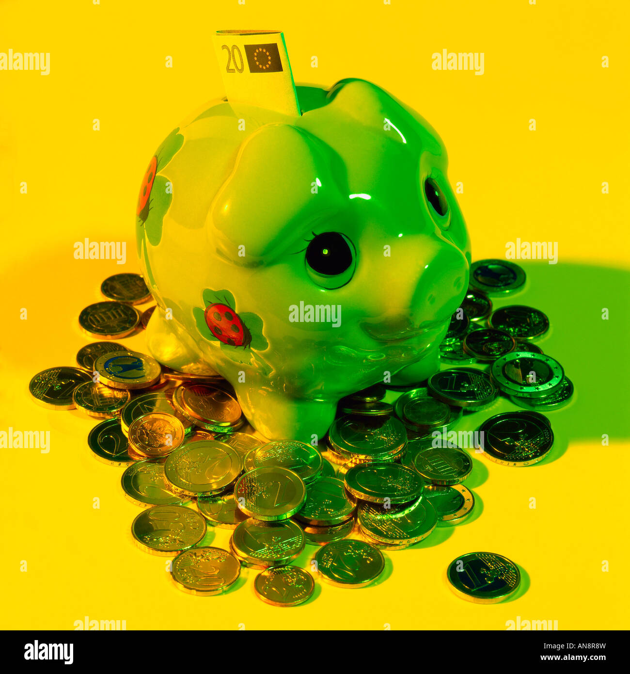 Piggy bank colored by yellow light Stock Photo