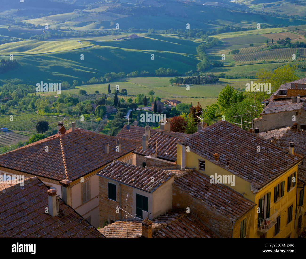 Tuscany Italy Tiled roofs of Montepulciano with farms green fields and vineyards in the valley below Stock Photo