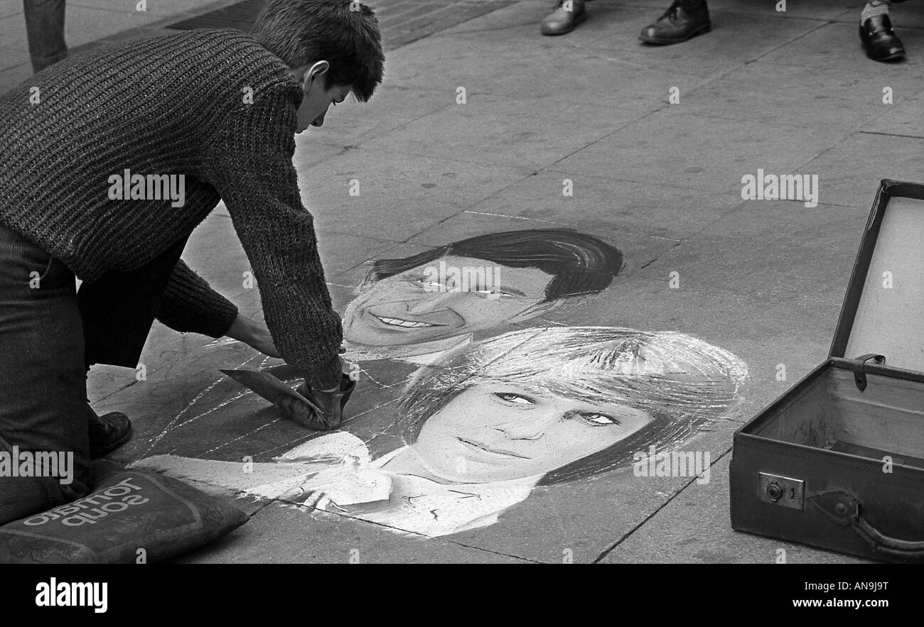 Street artist using chalk to create picture of Charles and Diana on paving slabs. Stock Photo