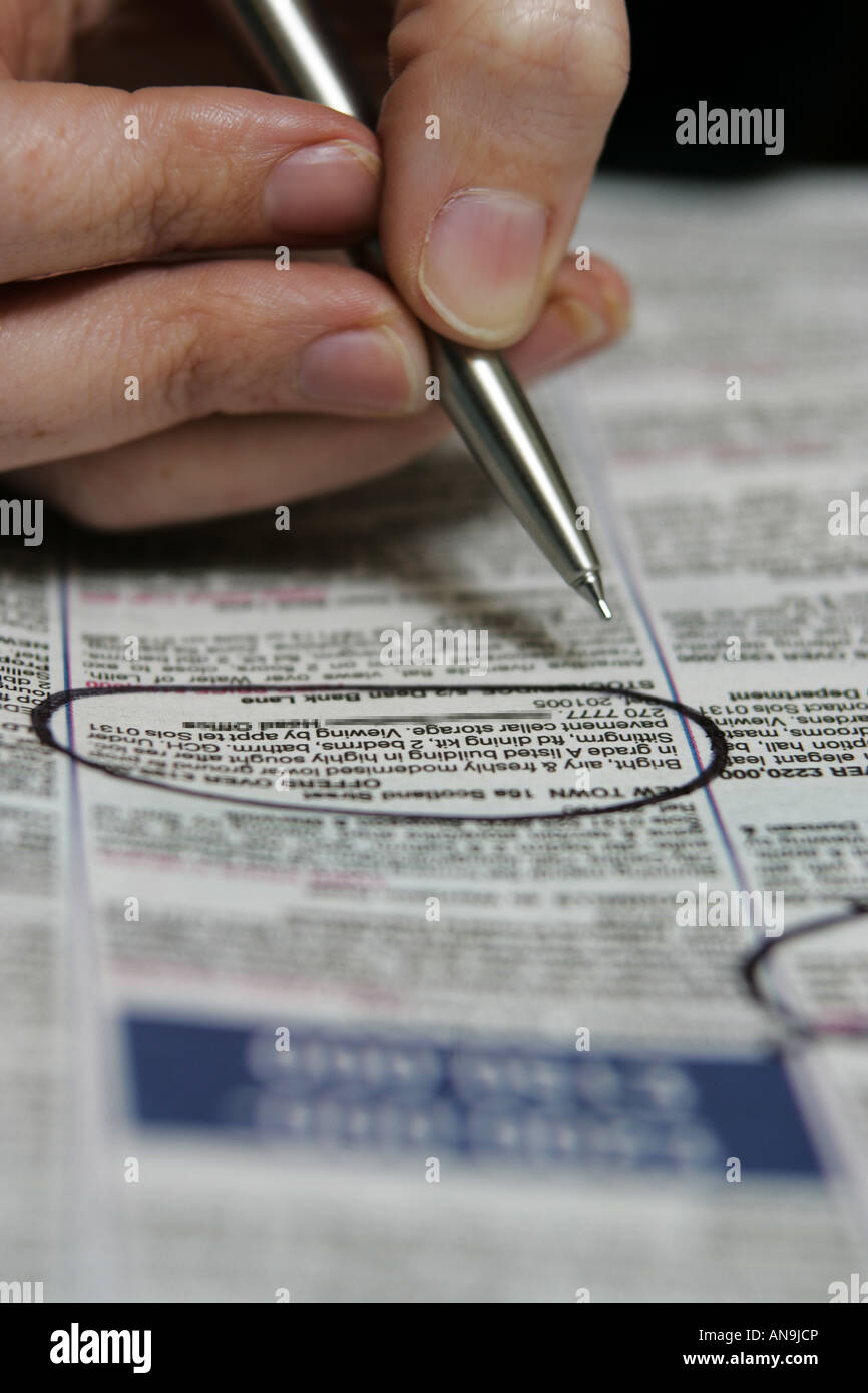 A person searches the classified adverts for a new home. Stock Photo