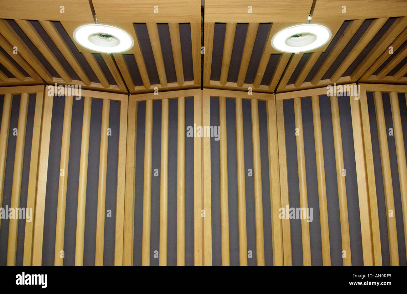 Interior of National Assembly for Wales showing debating chamber wooden paneling and lights Cardiff South Wales UK Stock Photo