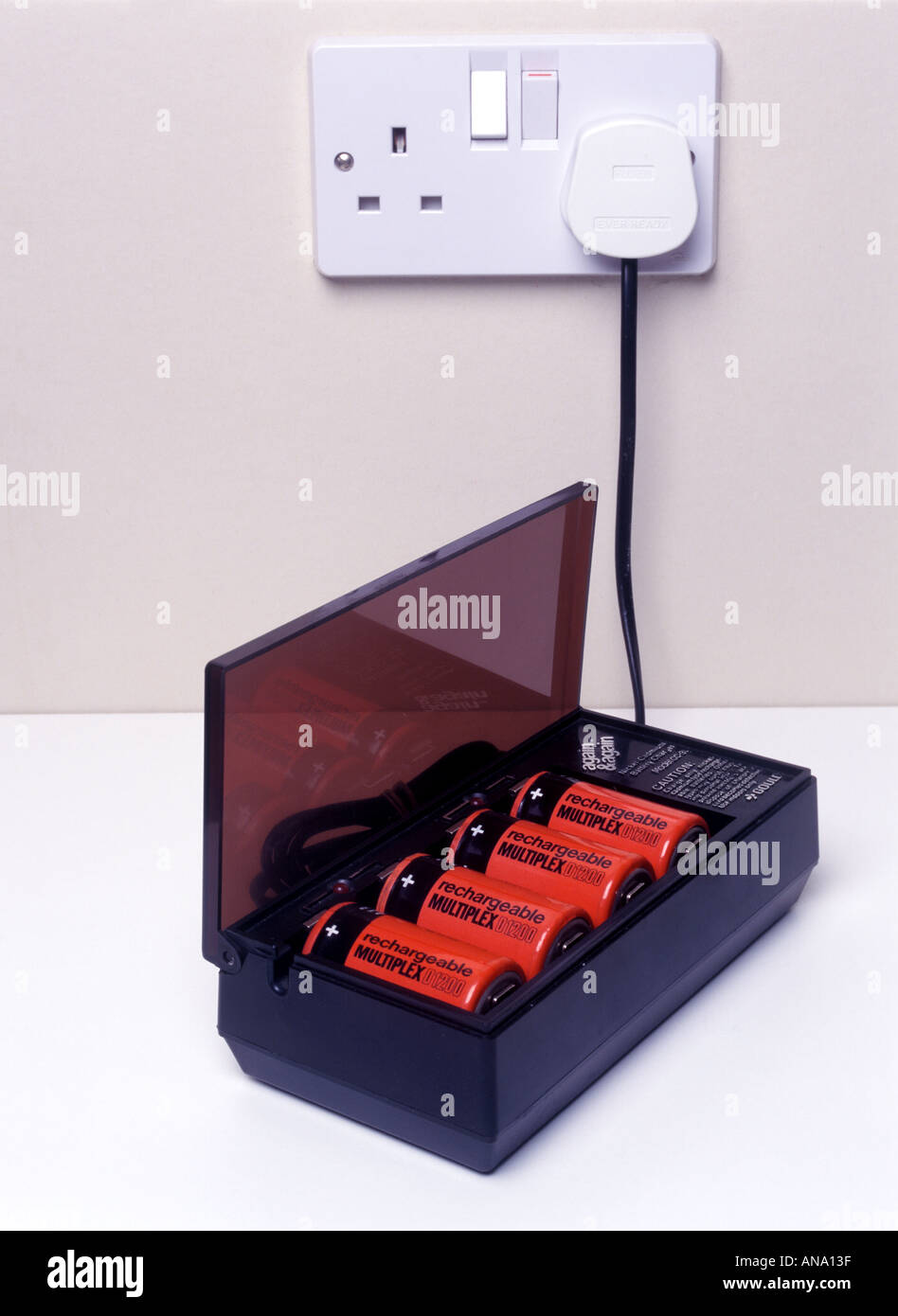 Battery charger charging four D size rechargeable cells Stock Photo