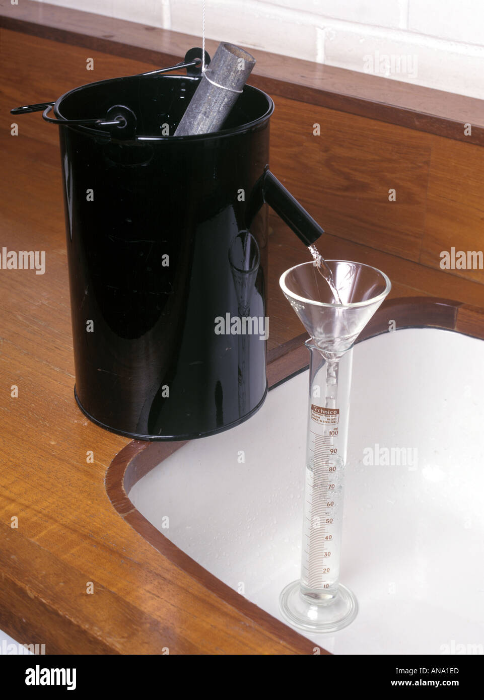 object lowered into displacement can to measure its volume Stock Photo