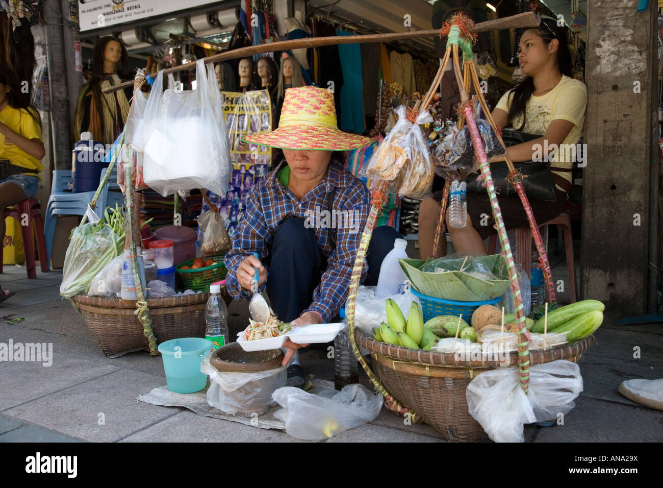 Woman street vendor selling salad, rice and bananas, on the Khao San road in Bangkok, Thailand Stock Photo