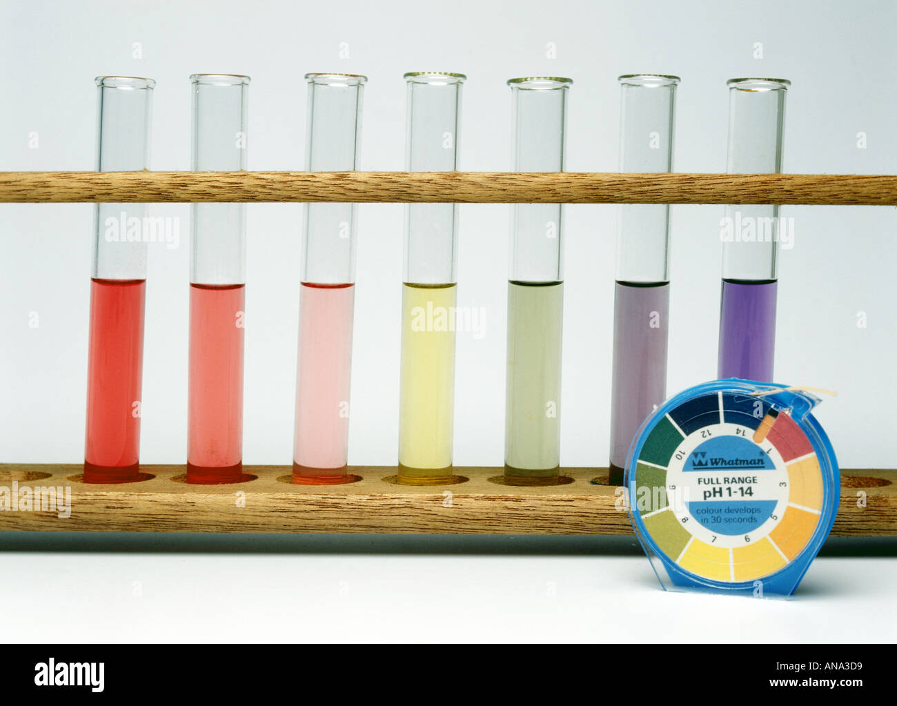 pH indicator paper and test tubes ranging from acid red to alkaline blue Stock Photo