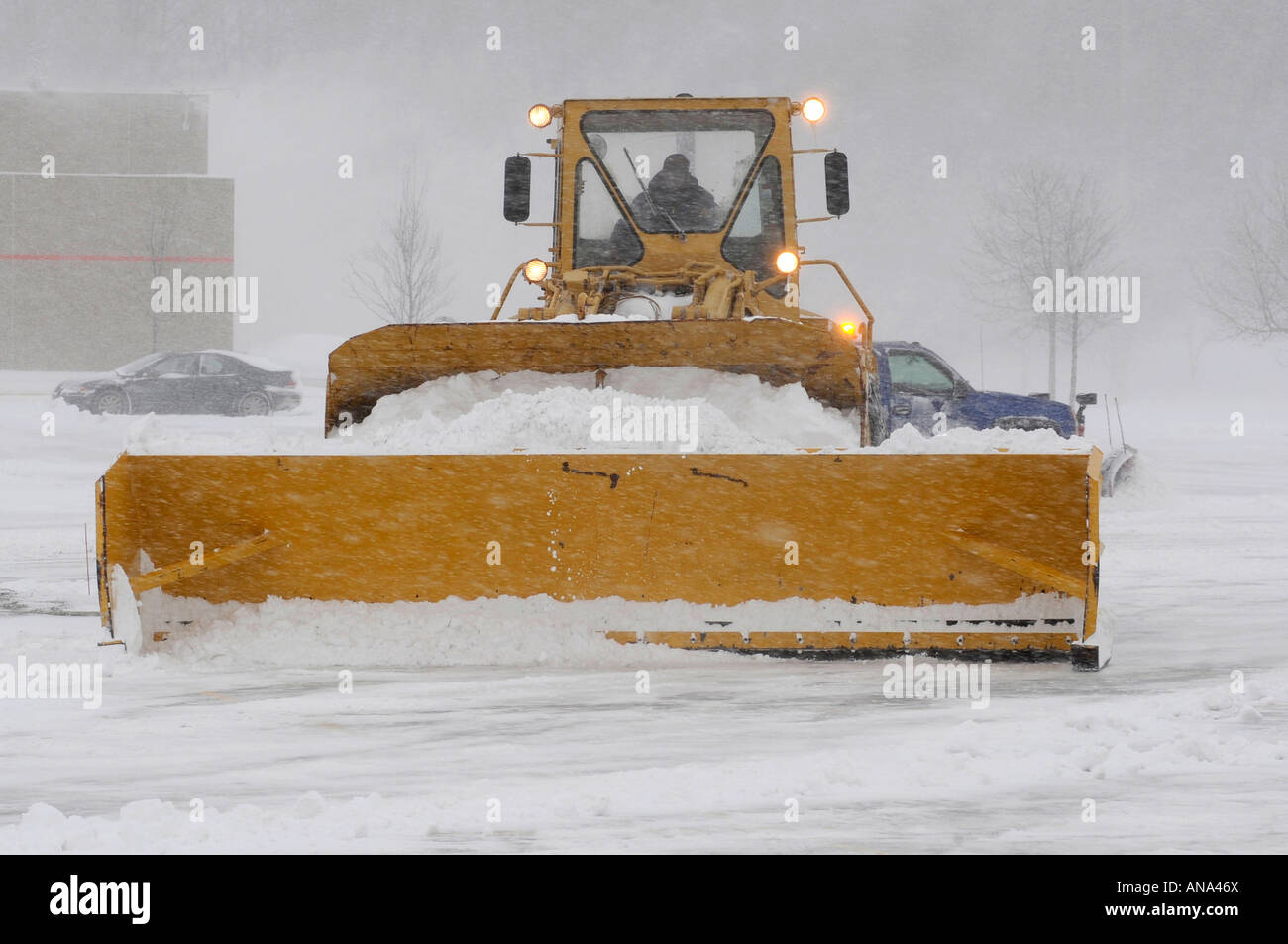 Snow plow busy clearing streets and roads during Winter season in the suburbs of Detroit Michigan Stock Photo