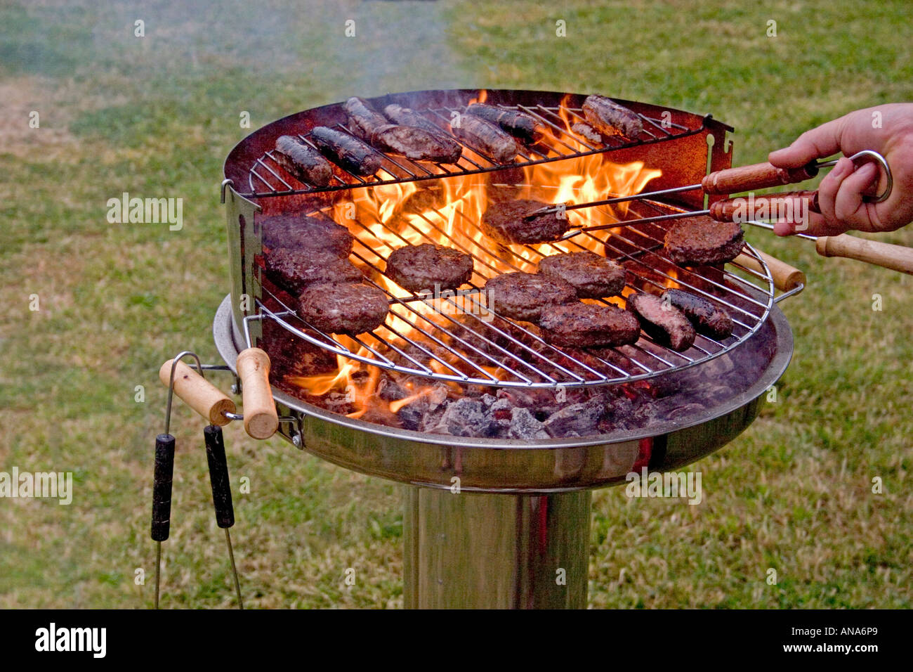 COOKING SAUSAGES AND BEEFBURGERS ON BARBECUE Stock Photo