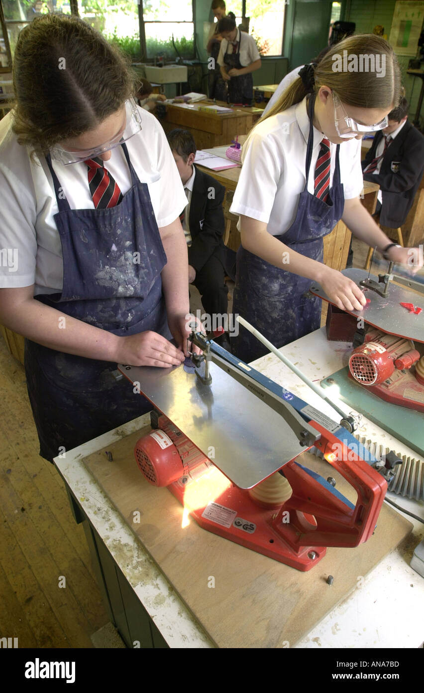 Female students work with a jig saw in resistant materials UK Stock Photo