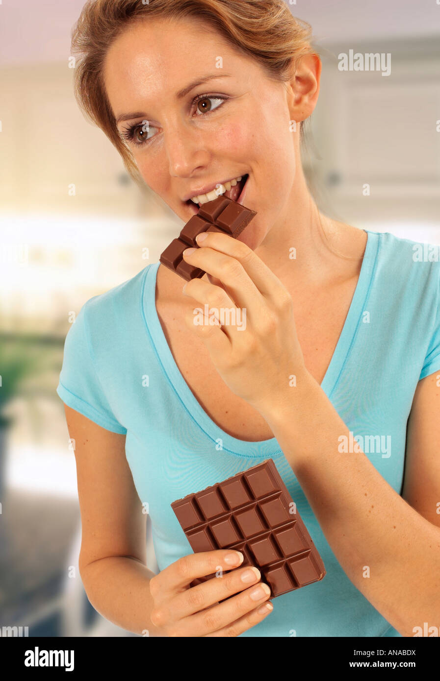 GIRL EATING BAR OF CHOCOLATE Stock Photo