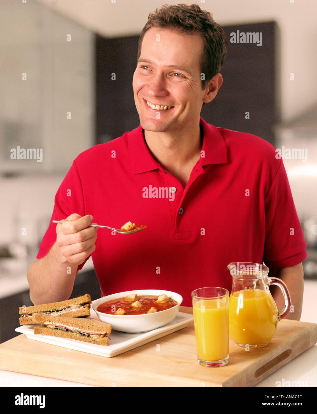 MAN IN KITCHEN EATING SOUP FOR LUNCH Stock Photo Alamy