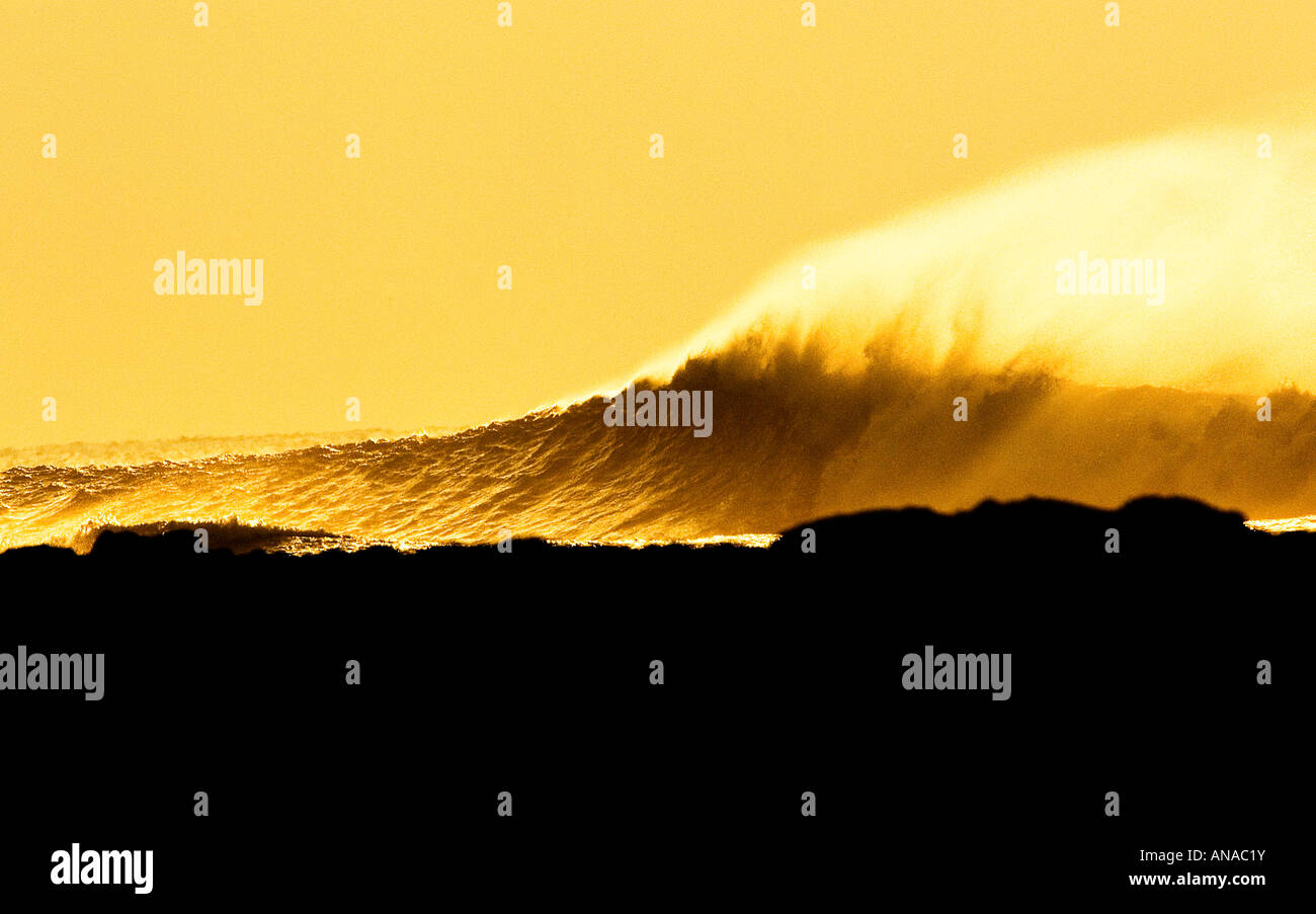 Wave breaking down the headland at Downend point, Croyde, North Devon as the sun sets. Stock Photo