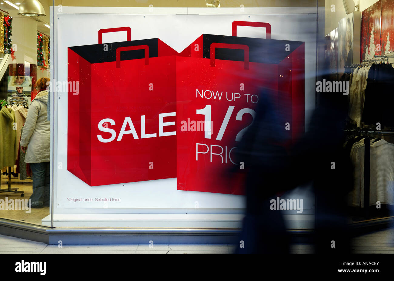 Shop window sale signs with passing blurred pedestrians in the foreground, Edinburgh, Scotland Stock Photo