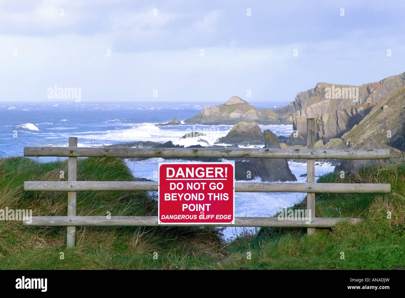 Dangerous cliff edge with warning sign Stock Photo
