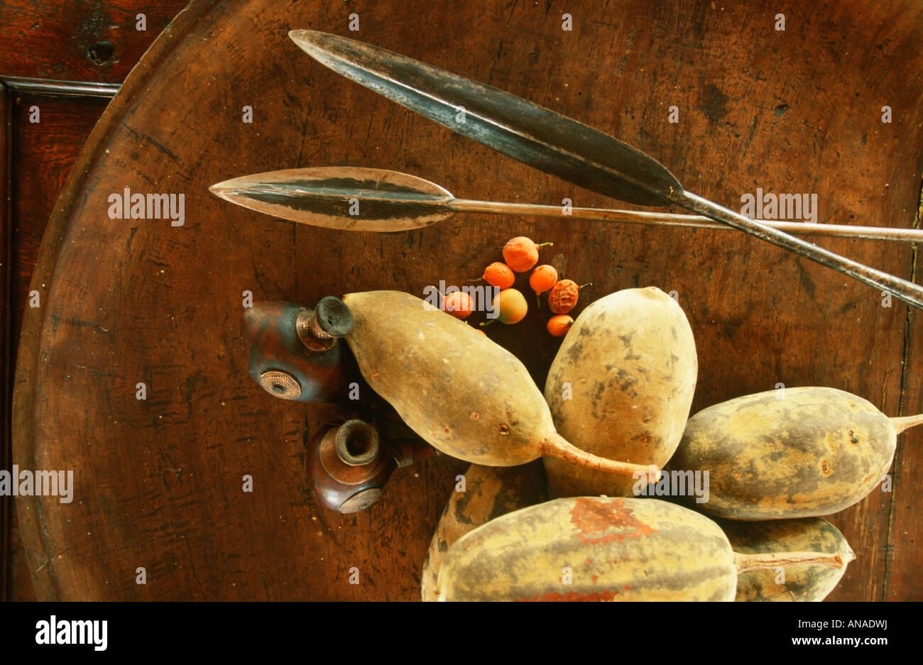 Décor in Jao camp showing spear heads, wooden pipes and baobab seeds in a large flat bowl Stock Photo