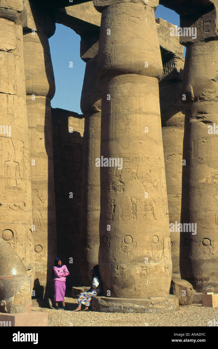 Upper Egypt Luxor East Bank Karnak Great Temple of Amun colonnade view with two local women Stock Photo