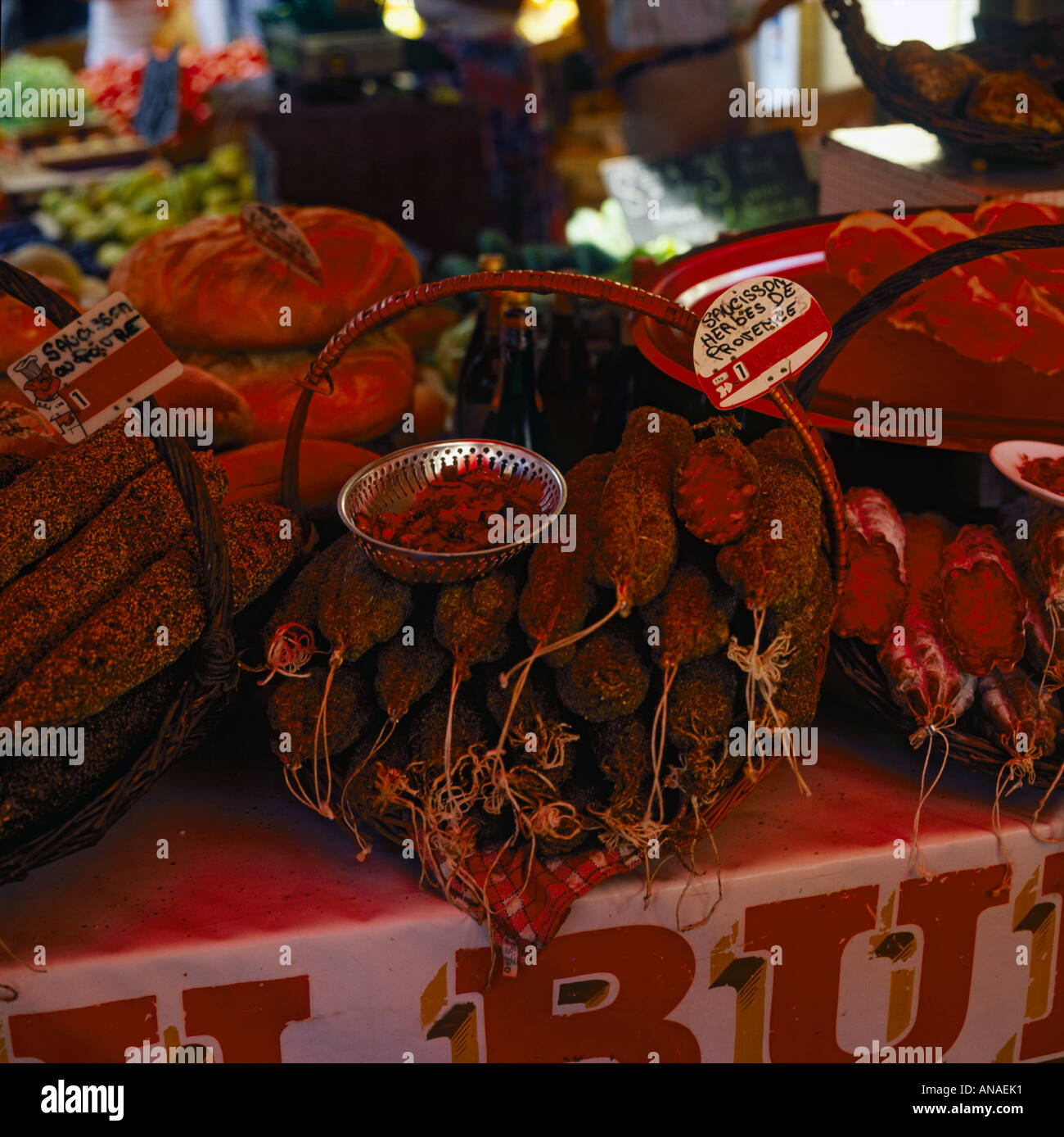 A colourful charuterie display of spicy meats and sausages in wicker baskets in a market in the South of France Stock Photo