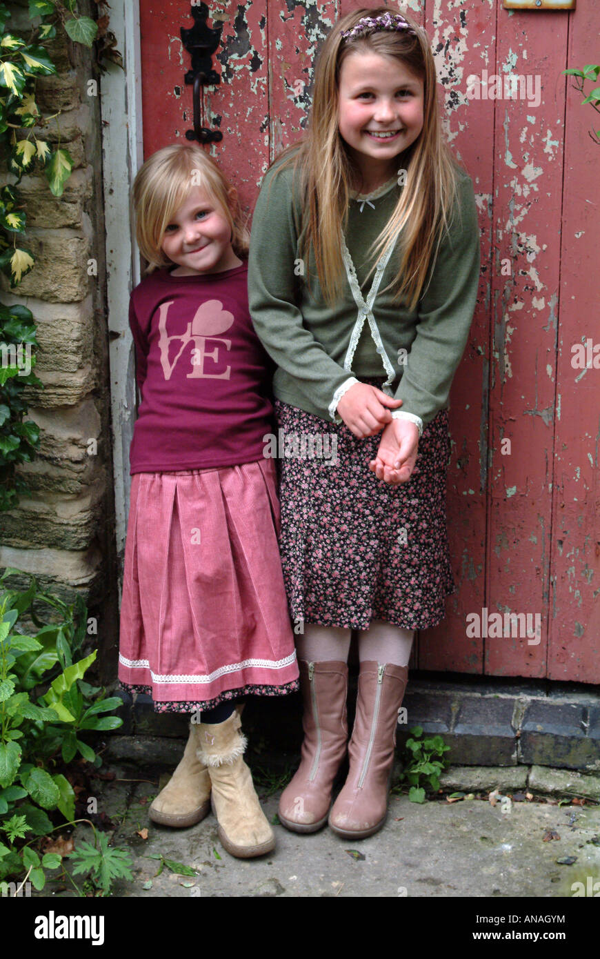 Portrait of two girls standing in front of a door Stock Photo