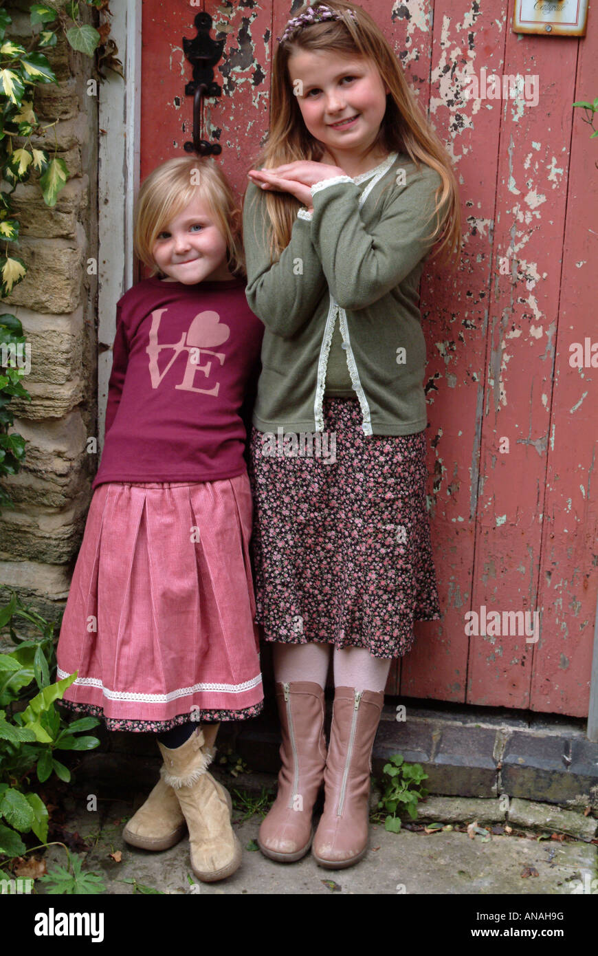 Portrait of two girls standing in front of a door Stock Photo - Alamy