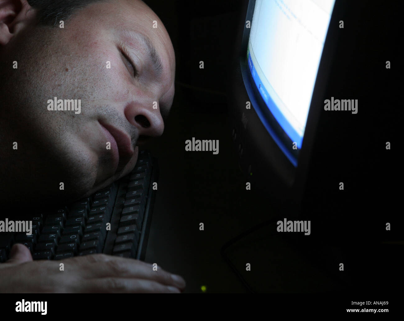 man fallen asleep at computer Stock Photo