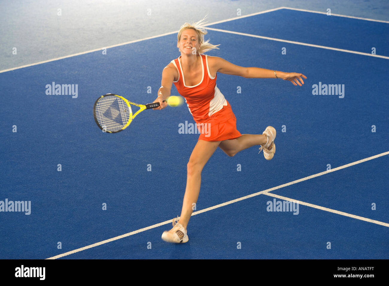woman in red sportswear playing indoor tennis Stock Photo Alamy