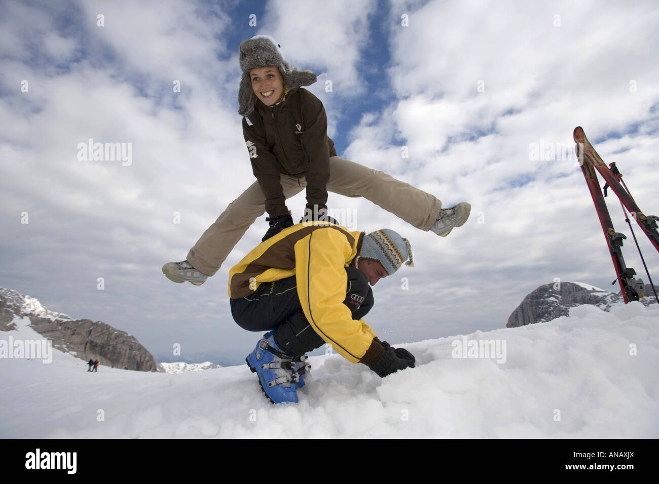 Woman doing a leapfrog over her boyfriend Stock Photo