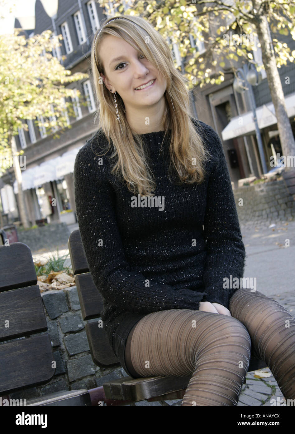 pretty blond woman with mini-skirt sitting on a bench Stock Photo - Alamy