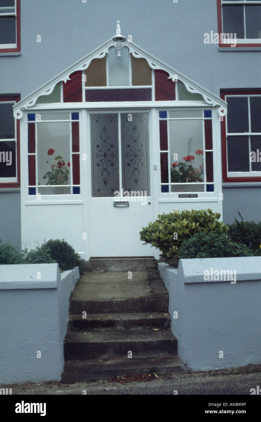 Steps to house with Victorian glass porch and stained glass Stock Photo