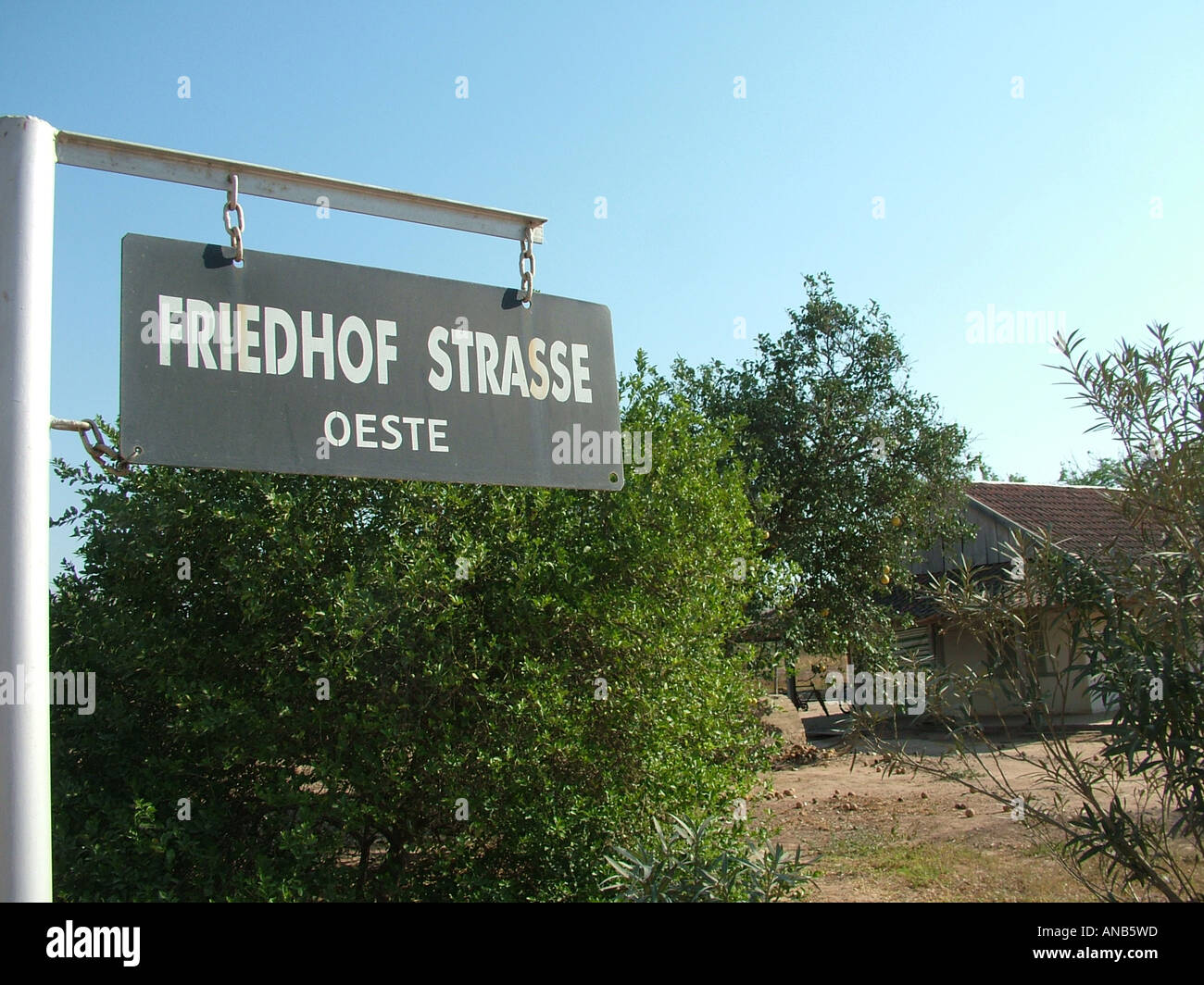 Street sign in mixed German and Spanish language in front of a house of the pioneer's time, Mennonite colony, Filadelfia Stock Photo