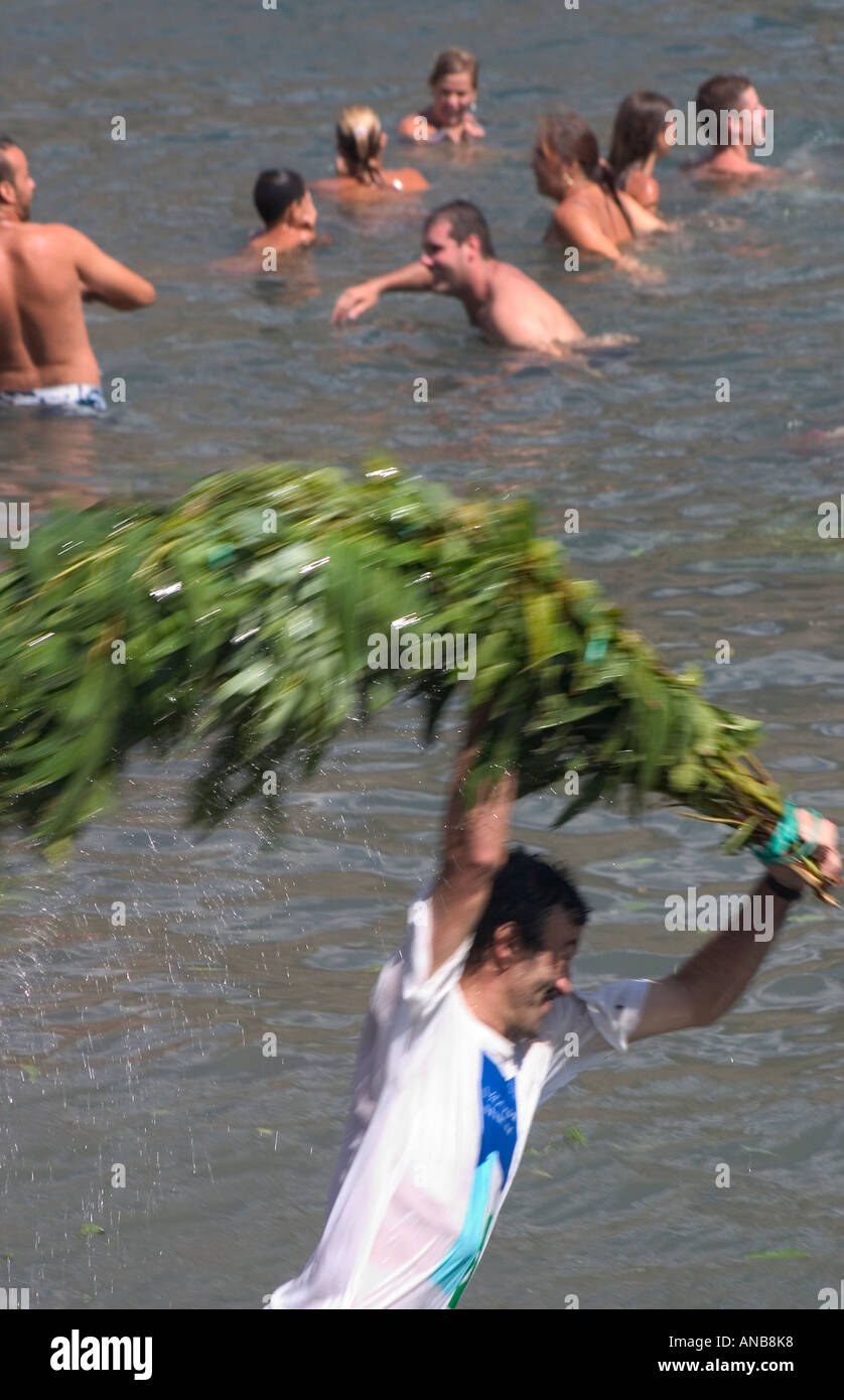 Spanish man thrashing the sea with branches at Fiesta de La Bajada de La Rama in Agaete on Gran Canaria Stock Photo