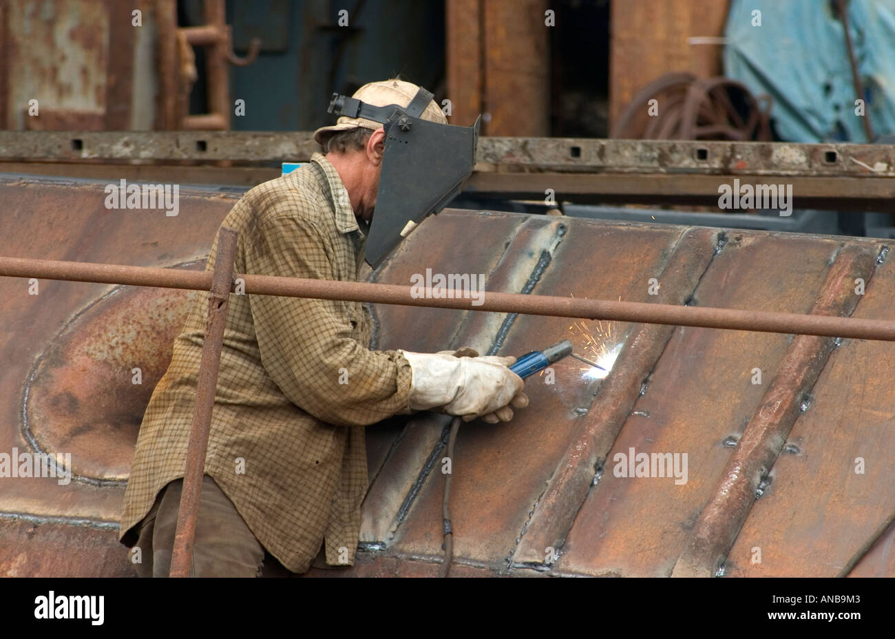 Welder working on old rusting Russian trawler in Las Palmas, Gran Canaria Stock Photo